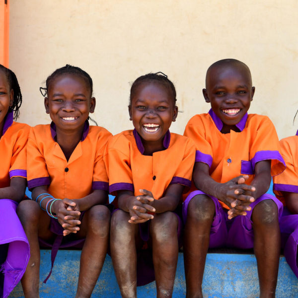 Children smiling together in a playground in the East of Cameroon.