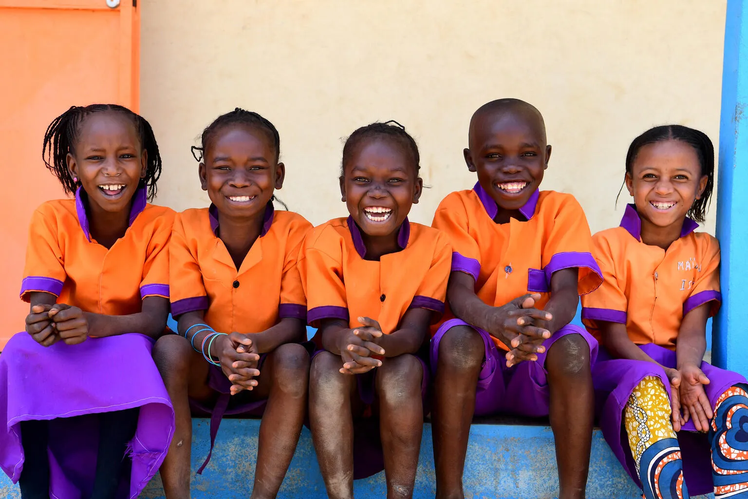 Children smiling together in a playground in the East of Cameroon.