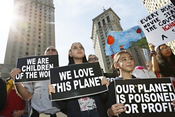 Young girls on a climate change protest holding placcards.