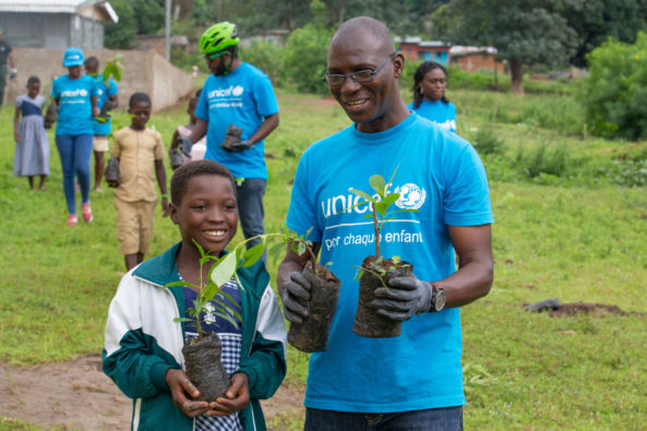 Child smiling with plant in hand