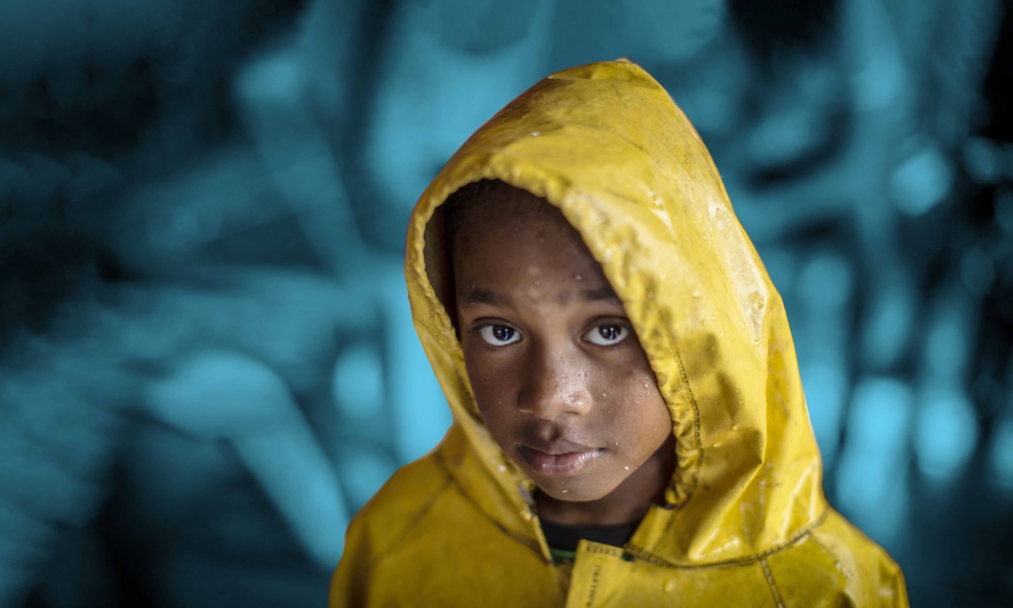 Young child wearing a yellow raincoat.