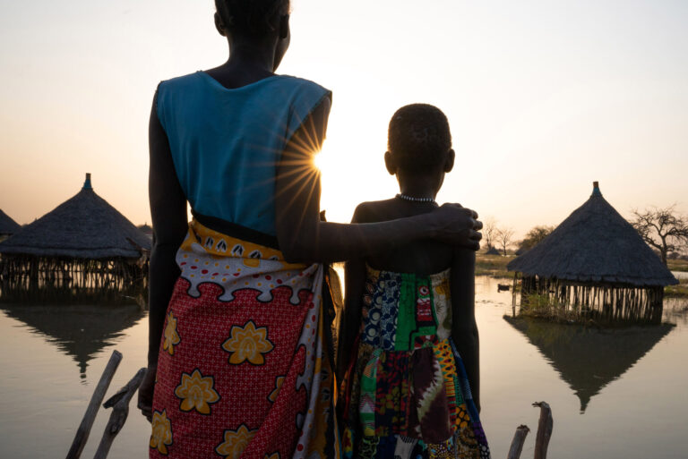 A mother and daughter look out over submerged houses in Panyagor in Twic East, Jonglei State in South Sudan.