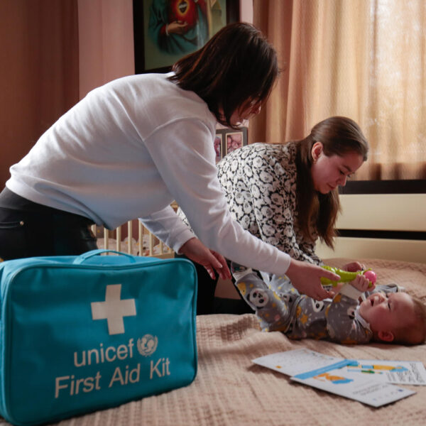9-month-old Damien being examined at home by Nurse Nadiia in a home-visit initiated by UNICEF.