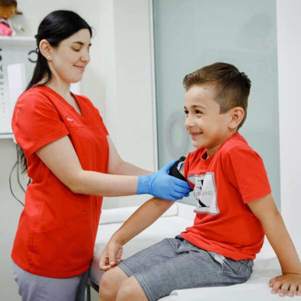 Six-year-old Mykhailyk during his pre-vaccination medical examination, conducted by the nurse at the clinic.