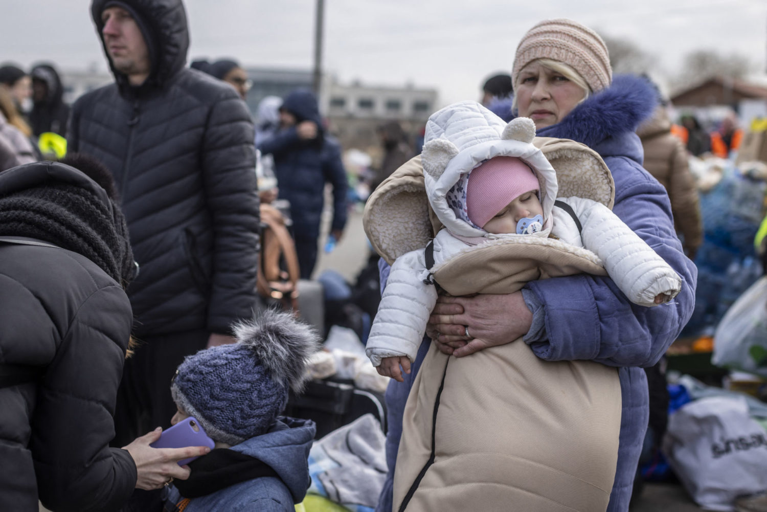 A woman holds a baby as Ukrainian citizens arrive at the Medyka pedestrian border crossing fleeing the conflict in Ukraine
