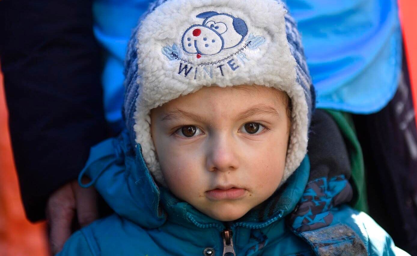 Young child from Ukraine wearing a fleece-lined hat