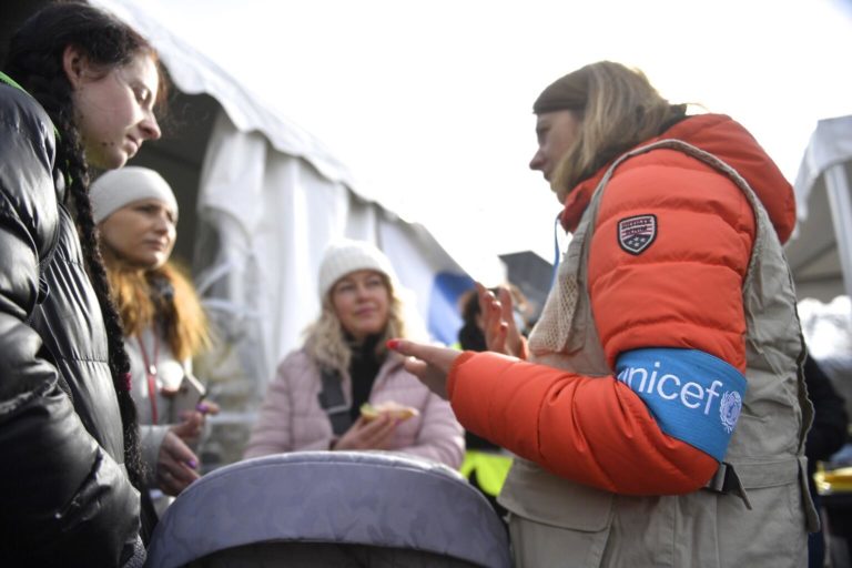 UNICEF staff member provides information to refugees from Ukraine outside a Blue Dot shelter