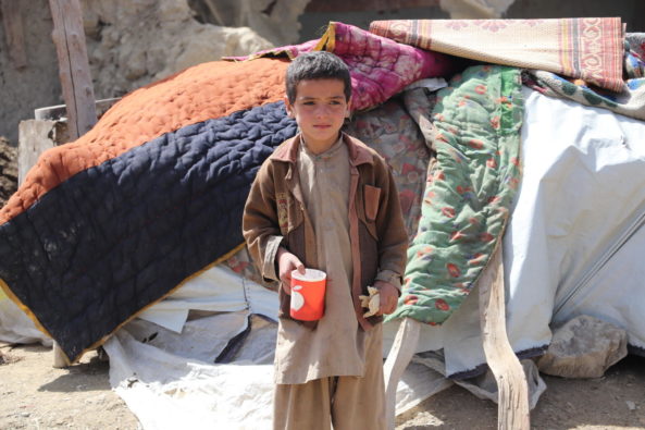 Halim, 8, from Gayan Village, Paktika Province standing in the street in front of a makeshift shelter following the Afghanistan earthquake.