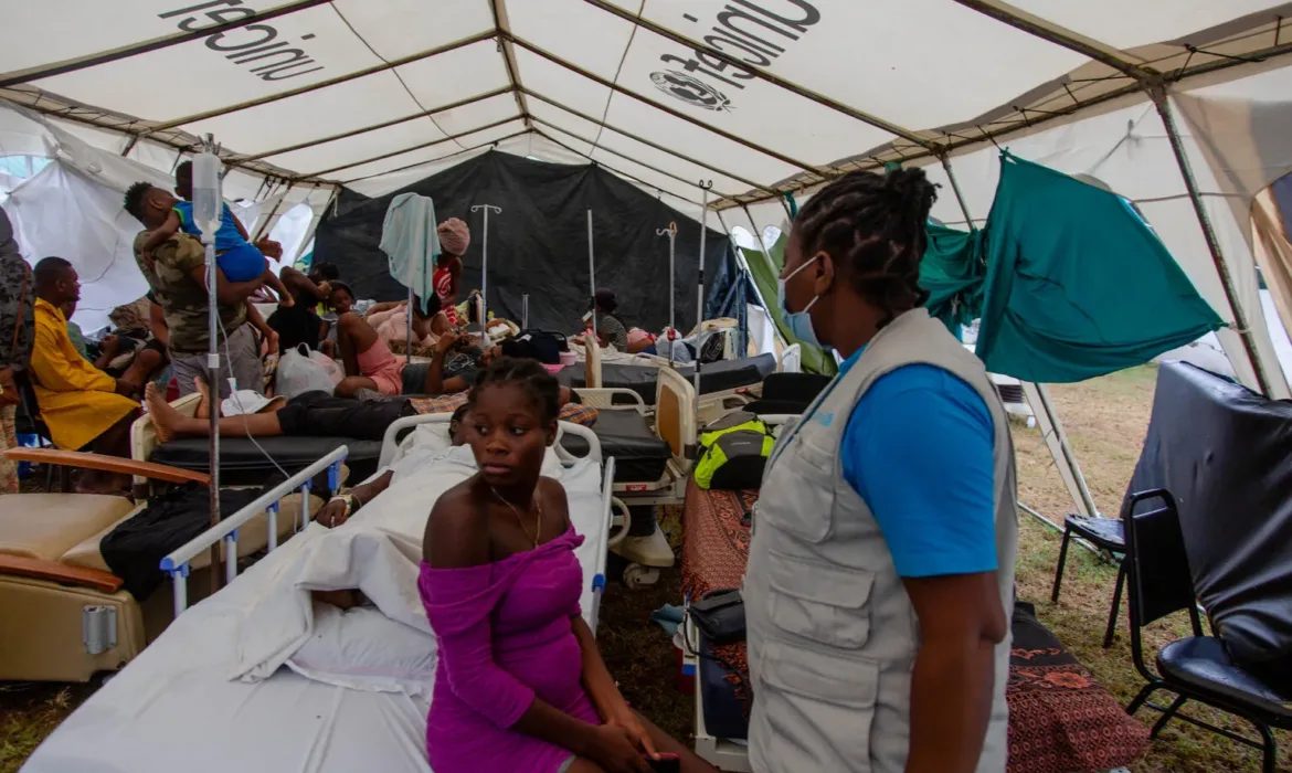 UNICEF Health Officer Eveline Chery visits patients receiving care at a UNICEF-supplied emergency tent
