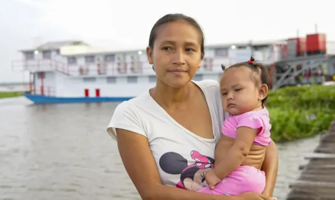 Mother and daughter stand in front of the riverboat hospital