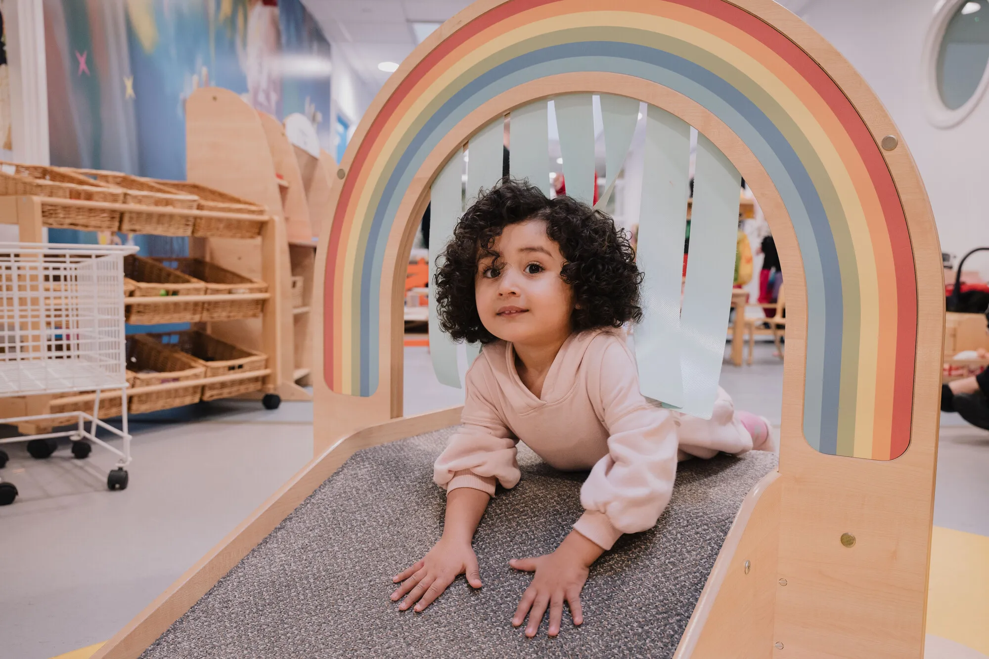 Aalyah posed under rainbow arch, Mini Explorers Daycare Centre. Photograph taken 13th February 2025.