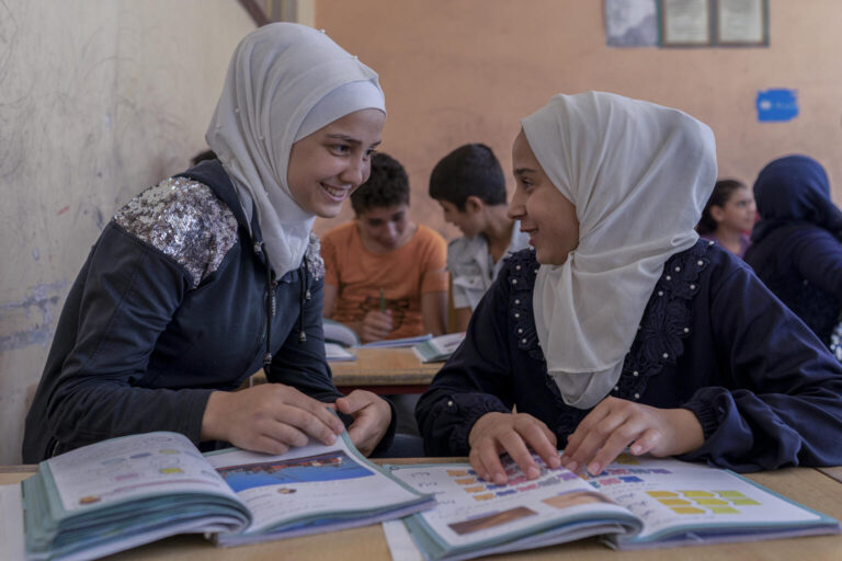 Nahla, 14, studies with her friend Abeer, 14, during a UNICEF-supported ‘Curriculum B’ class in Aleppo city.
