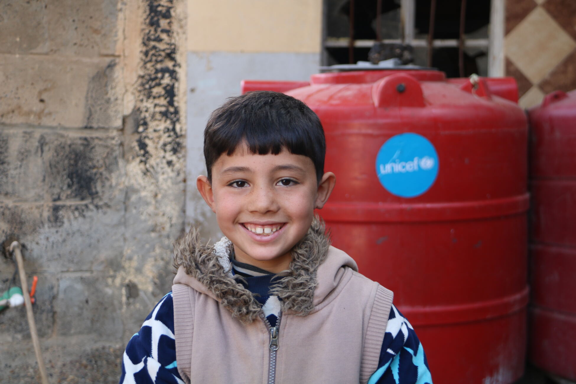 Seven year old Anas from Syria is happy water is now available at his school.