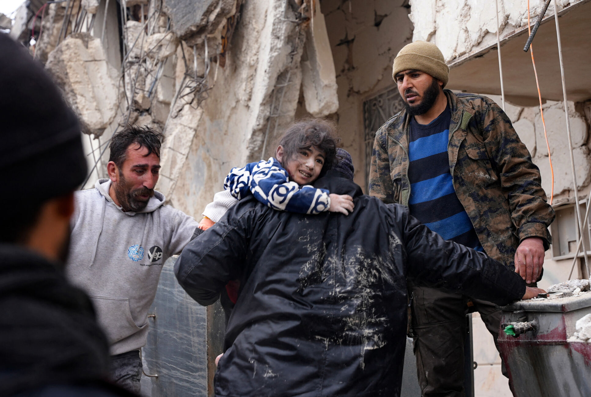 Child carried from the rubble of a collapsed building following the earthquake in Syria