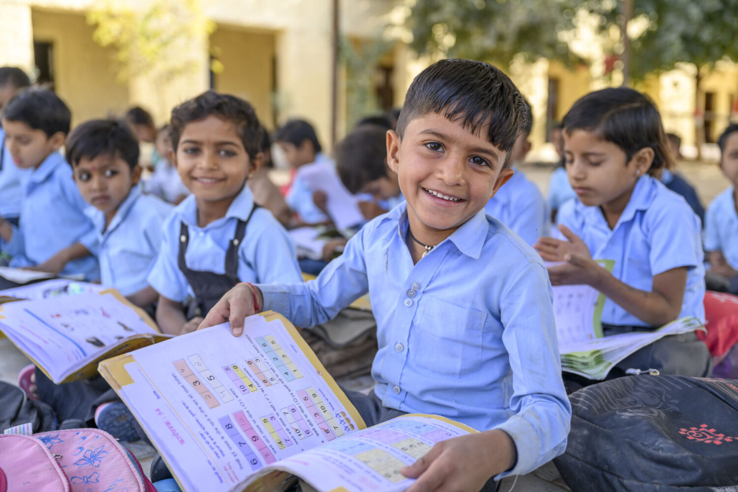 Image of school children smiling and reading books