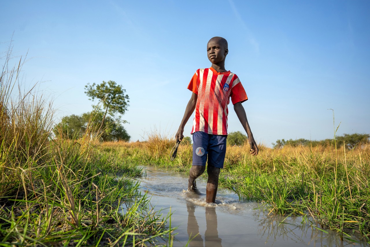 13 year old Panyagor But wades through flood water in the village of Panyagor in Twic East, Jonglei State in South Sudan.