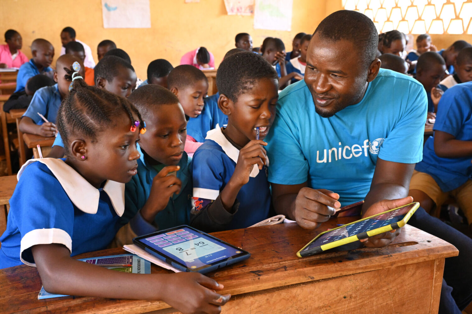 Children learning with tablets in a classroom setting.