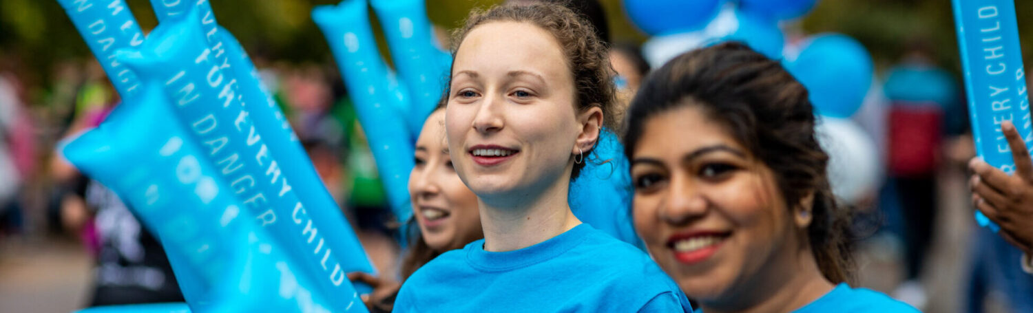 People cheering on UNICEF runners at an event.