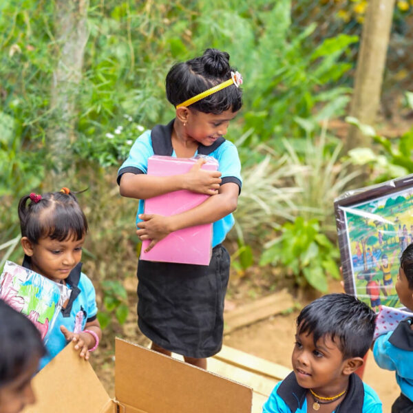 Group of children smiling upon receiving games and learning materials from UNICEF.