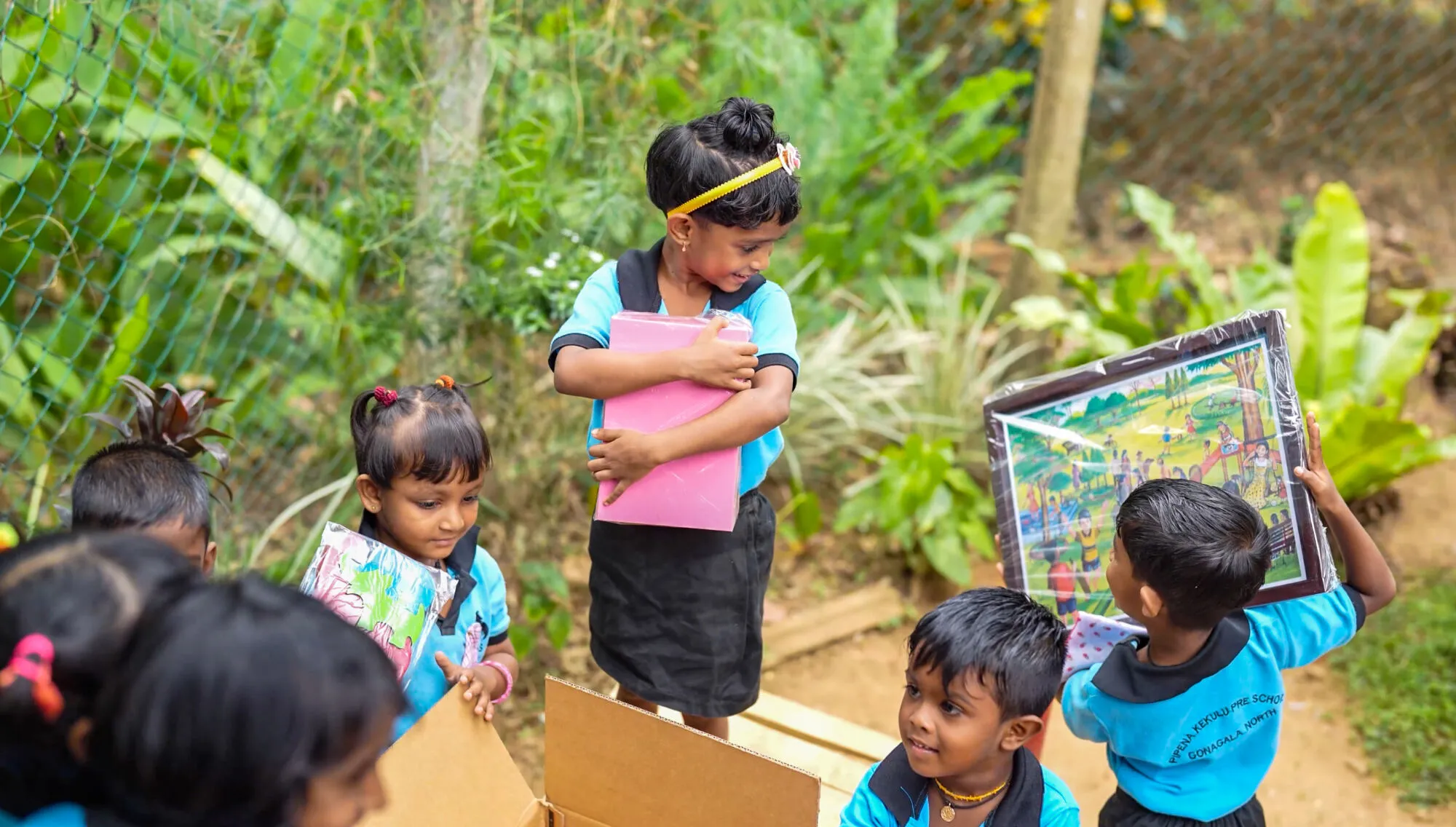 Group of children smiling upon receiving games and learning materials from UNICEF.