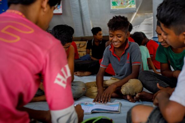 Nirob reads in a group of friends in a street hub in Bangladesh.