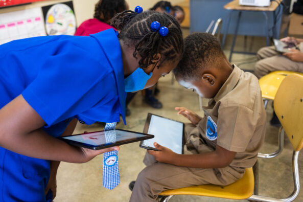 Ari reading an accessible digital text book with his friend in school