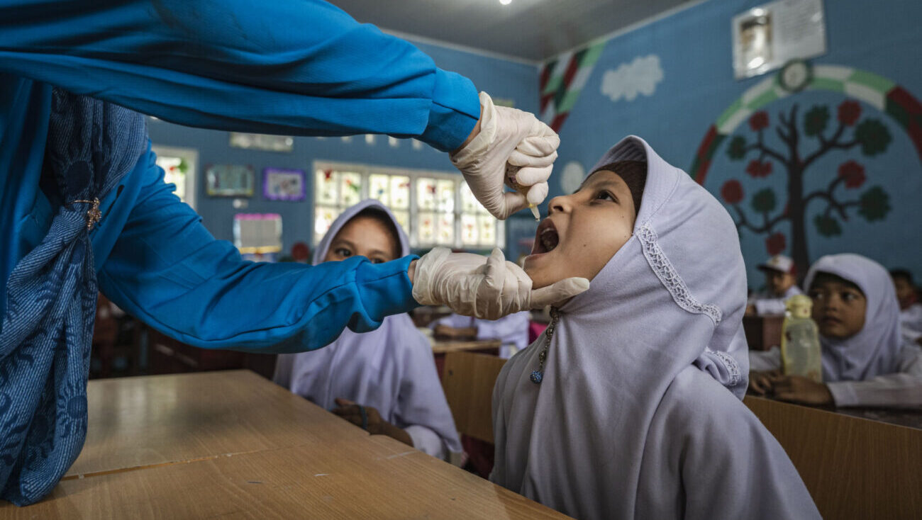 Child receiving vaccination in classroom