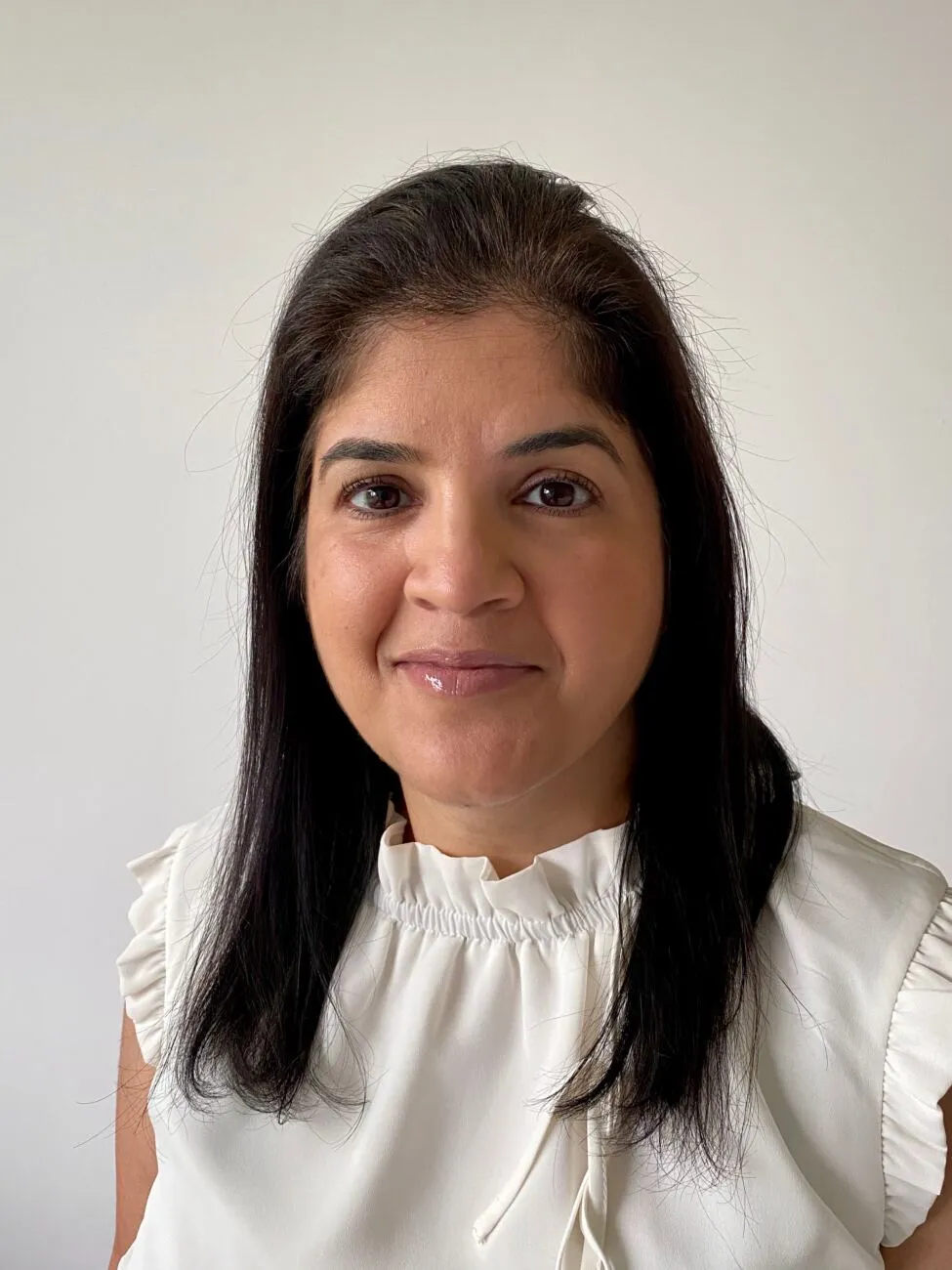 Wills and Trusts Solicitor Aarti Gupta smiling in a white blouse.