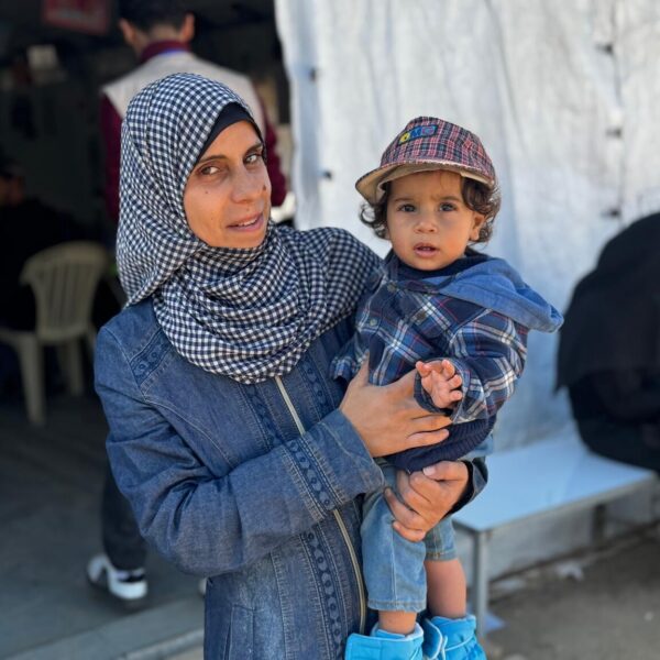 Mother Hanan holds her son, 1 years old, on her hip outside a UNICEF-supported nutrition point.