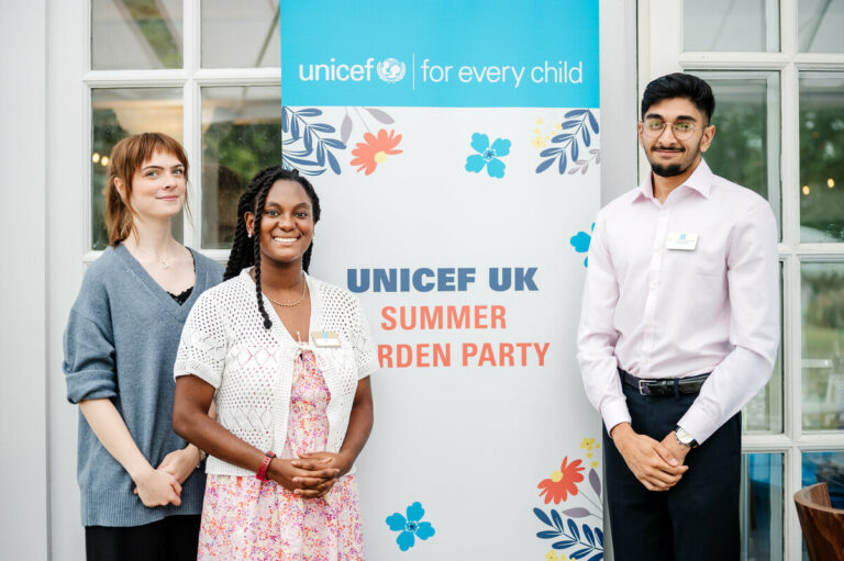 Young people standing in front of UNICEF UK banner.