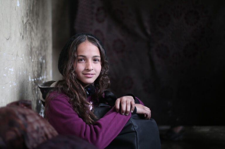 A displaced girl from Gaza in a purple jumper