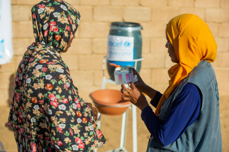 A mother receives guidance on sanitation and water cleanliness from a health worker as part of our emergency response.