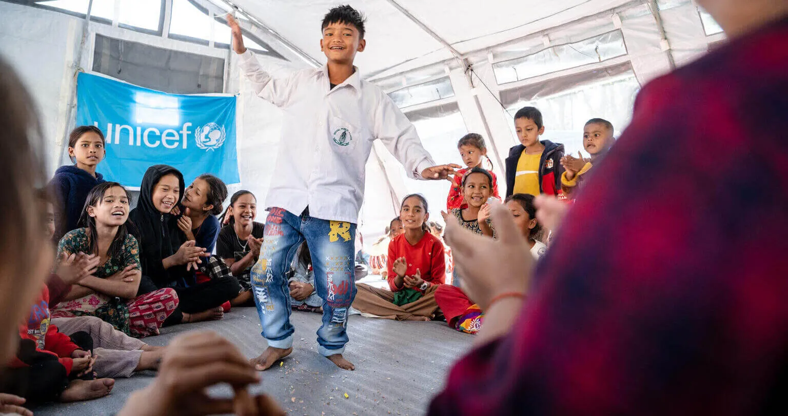 A child is playing in the middle of a circle, surrounded by children.