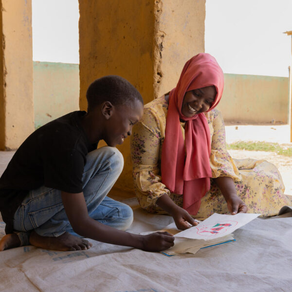 10-year old Khalid interacts with a facilitator during a drawing and art session at a UNICEF-supported safe space in Atbara town in River Nile state.