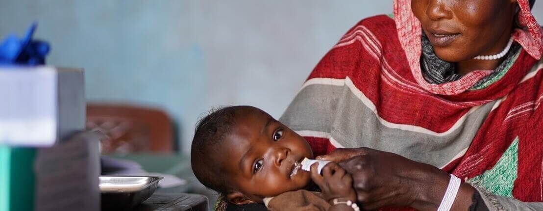 Halimah feeds her 7-month daughter Asyaa with a nutrition supplement.