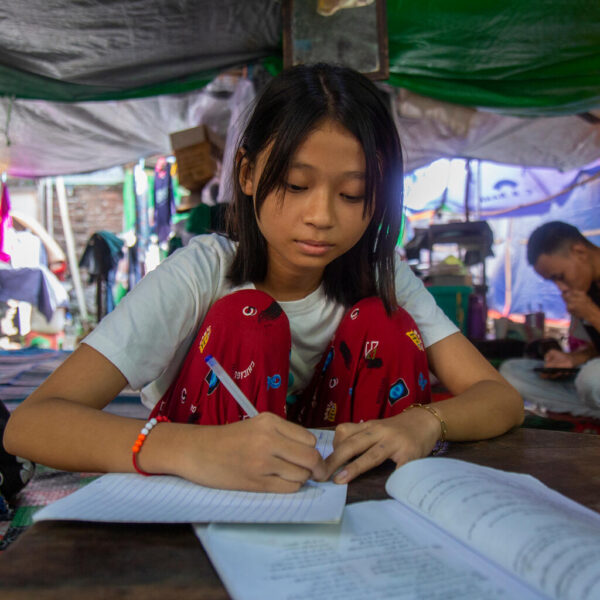 Yati Naing Oo (13 year-old girl) is putting books into her school bag inside her temporary shelter at Pyigyi Yanlone Ward, Aung Myay Thar Zan Township