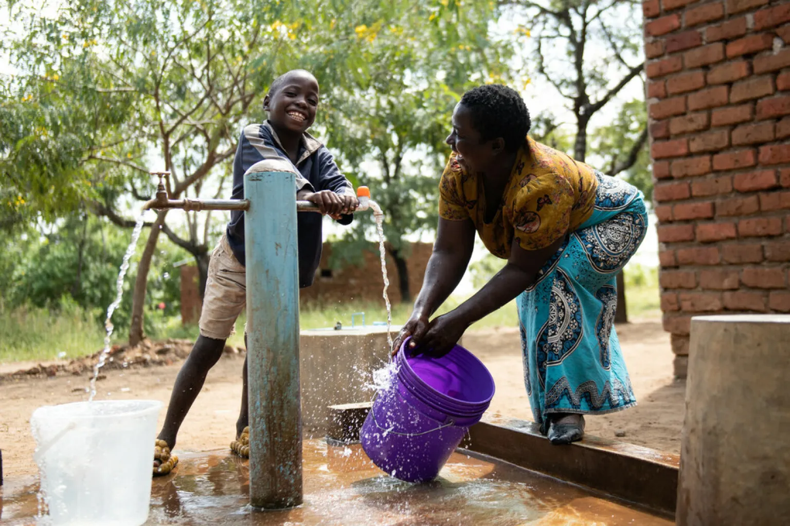 Joyce Mauzeni and her son 9-year-old Miracle Osman fetch water from a tap the children’s corner in Nankuyu Village in Blantyre southern Malawi on Sunday 21April 2024