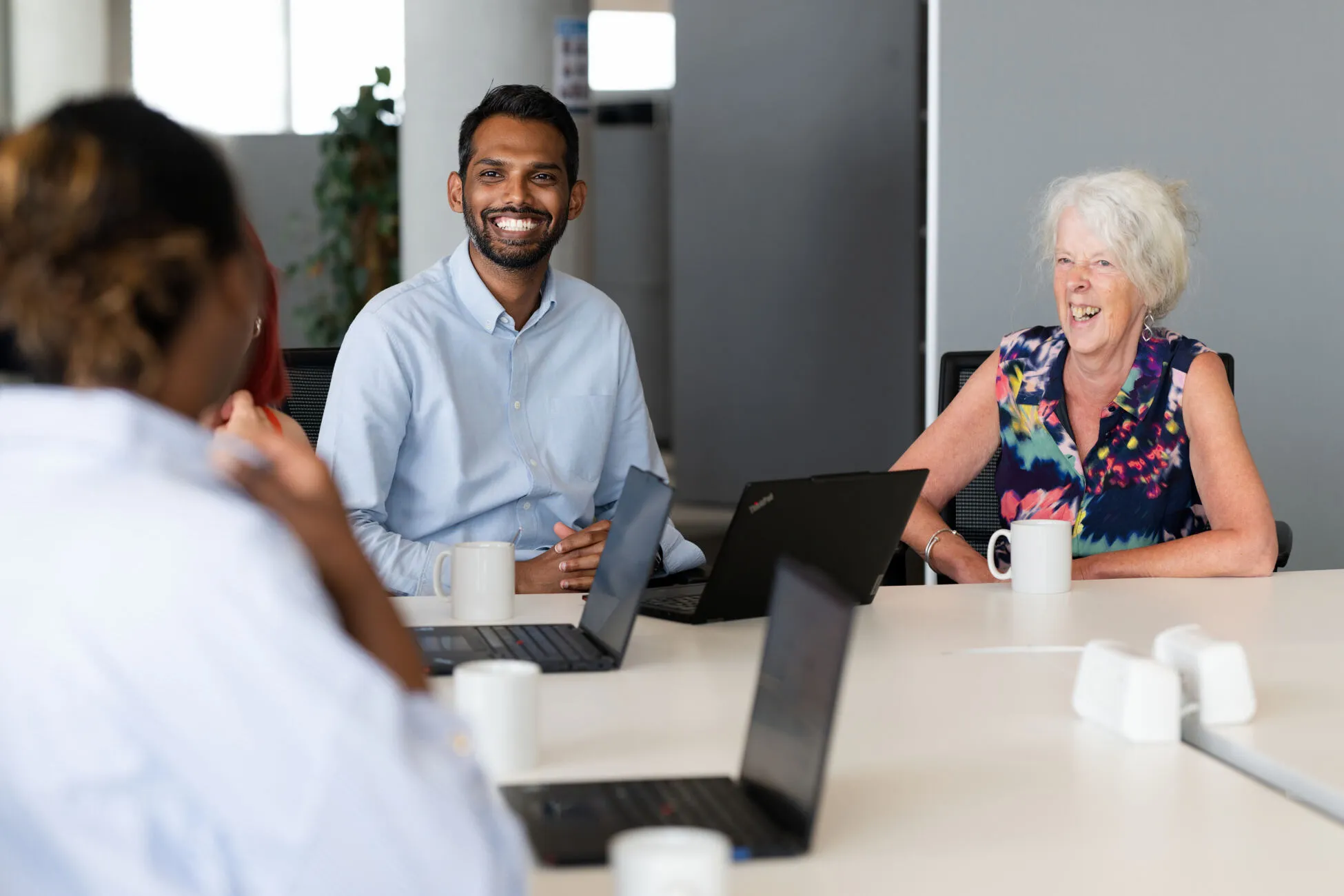 UNICEF UK colleagues laugh together at their desks.